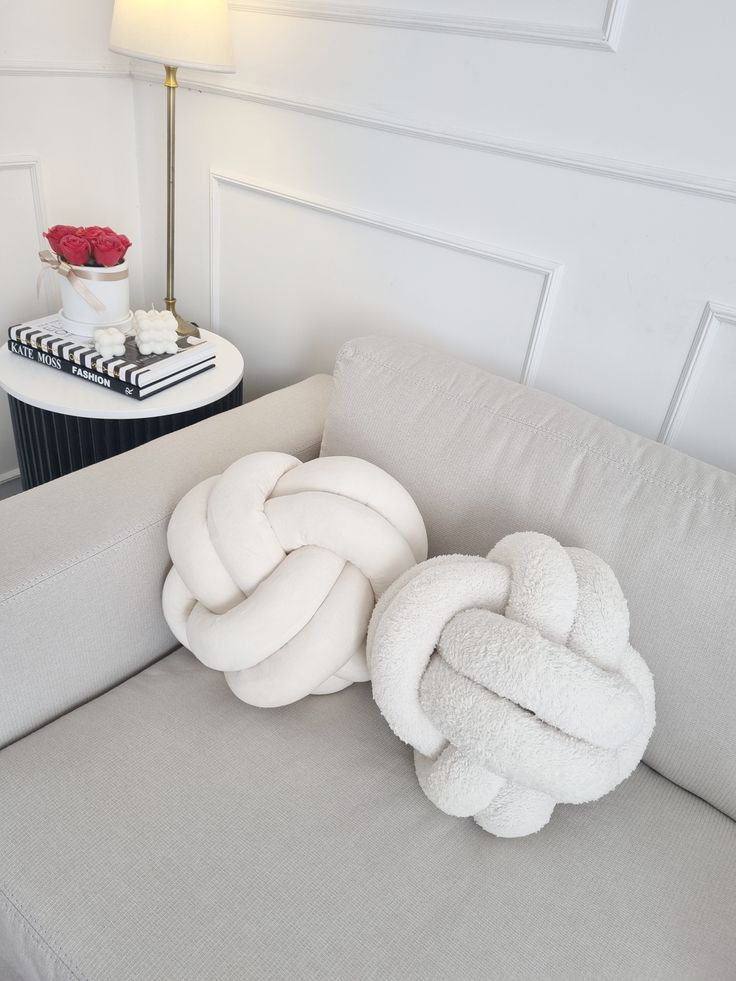 Cojín decorativo tipo nudo en textura suave tipo bouclé, diseño moderno que aporta estilo, confort y un toque exclusivo a cualquier espacio.